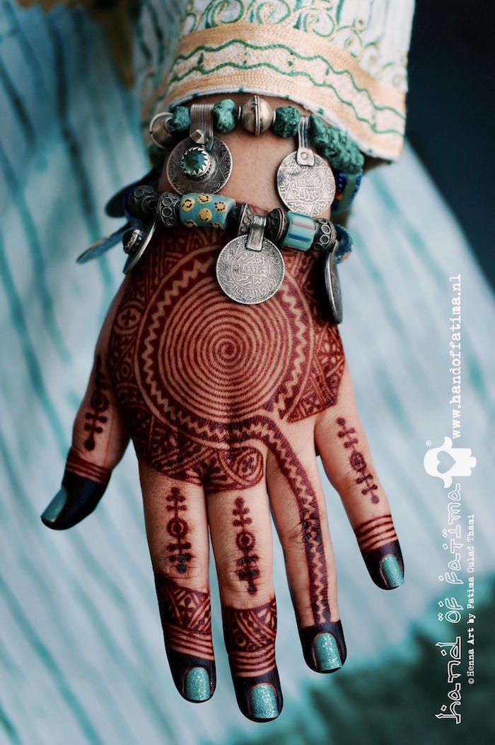 motif henné main séché marron avec spiral sur le dessus et motifs sur les doigts 