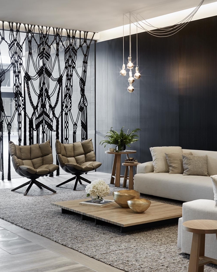 design intérieur moderne aux murs foncés avec suspension luminaire en verre et fauteuil en cuir, idée séparation pièce avec rideaux macramé