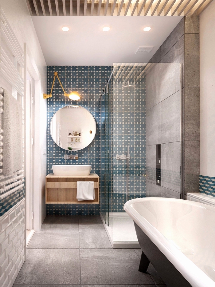 une salle de bains moderne en gris avec faience carreaux de ciment à motifs subtils en bleu canard qui définit l'espace derrière le lavabo