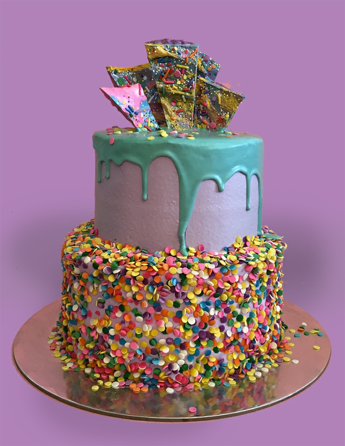 gâteau d'anniversaire aux flocons colorés, glaçage violet, dessert sculptés en pâte à sucre