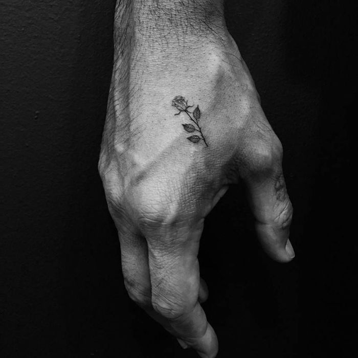 photo de tatouage homme discret main petit tattoo de rose détaillée noir et blanc