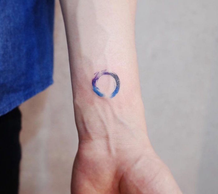 petit tatouage aquarelle rond coloré bleu et violet type tattoo discret abstrait sur le poignet homme