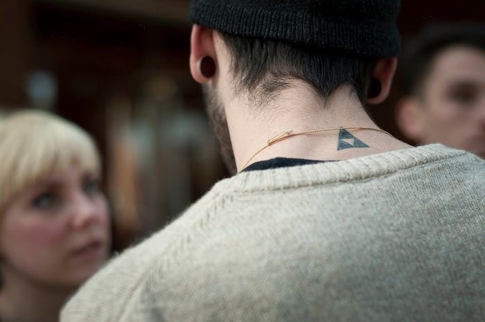 photo tatouage homme discret dans le cou petit triangle simple minimaliste