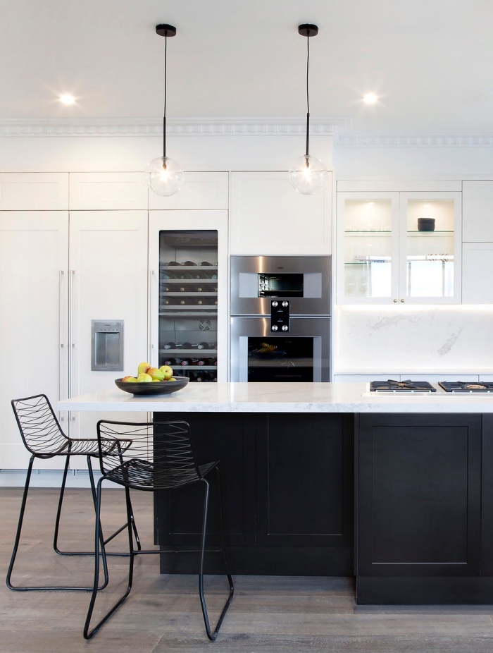 cuisine avec ilot cuisson et espace de rangement supplémentaire associant un plan de travail en quartz blanc avec une façade noir mat tendance