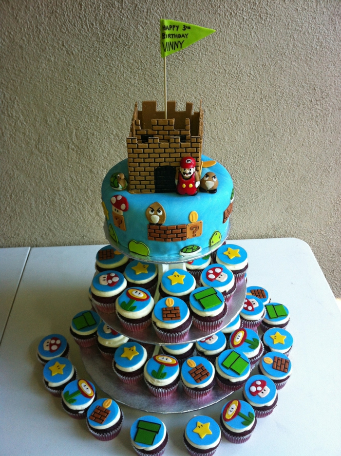gâteau à cupcakes super Mario, forteresse avec drapeau vert, plusieurs petits cakes empilés