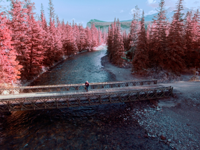 pont traversant une rivière, arbres aux feuilles rougeoyantes, arrière plan montagnes