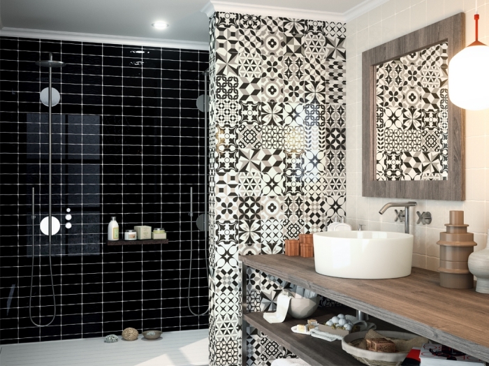un pan de mur en faience carreaux de ciment à motifs patchwork qui séparent visuellement le lavabo et la douche italienne avec carrelage noir brillant