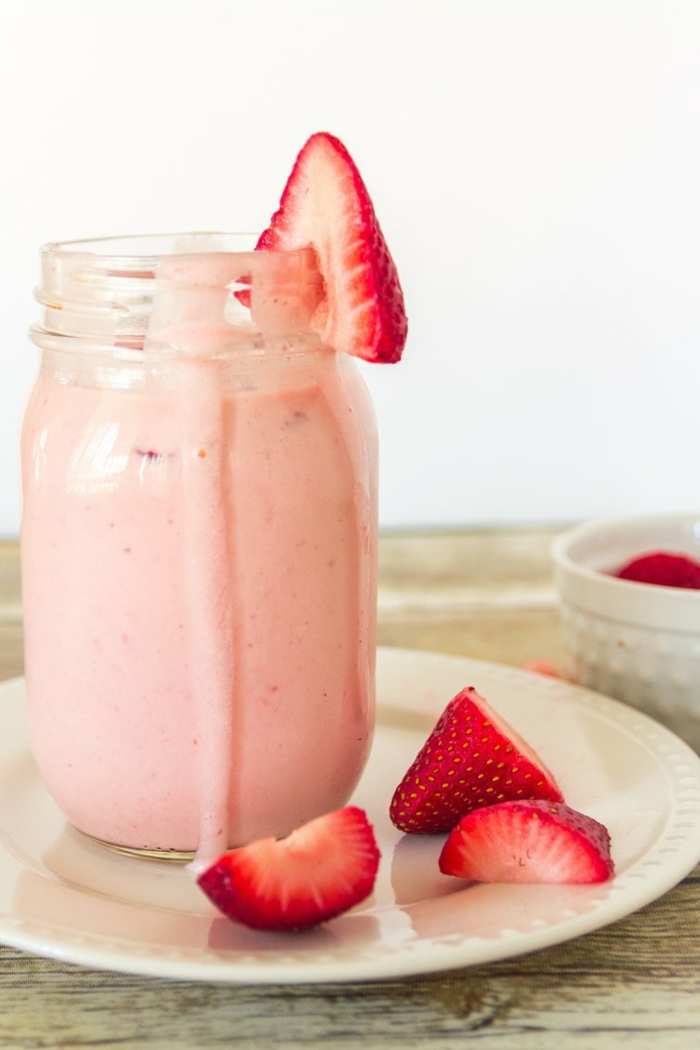 milkshake fraise aux fraises fraîches découpées, assiette blanche, fraises rouges, milkshake aux fruits frais