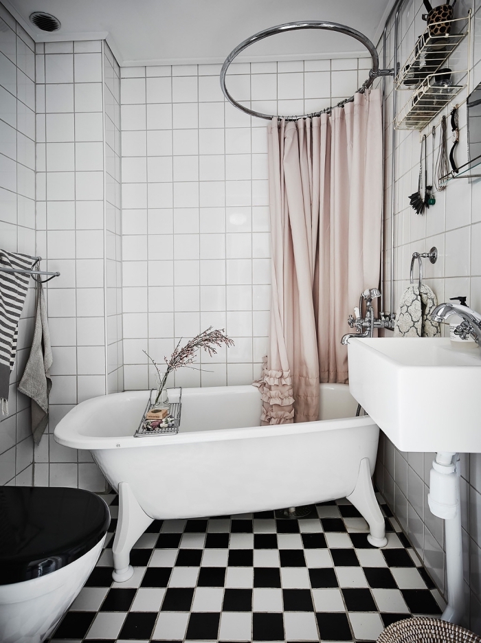 déco cozy dans une petite salle de bain en blanc et noir, modèle petite baignoire sur pieds, rangement gain place en métal