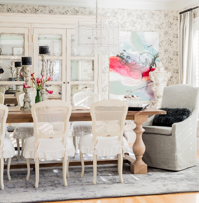 exemple de table salle à manger en bois avec des chaises vintage, fauteuil gris, tapis gris sur parquet bois clair, vaisselier blanc patiné