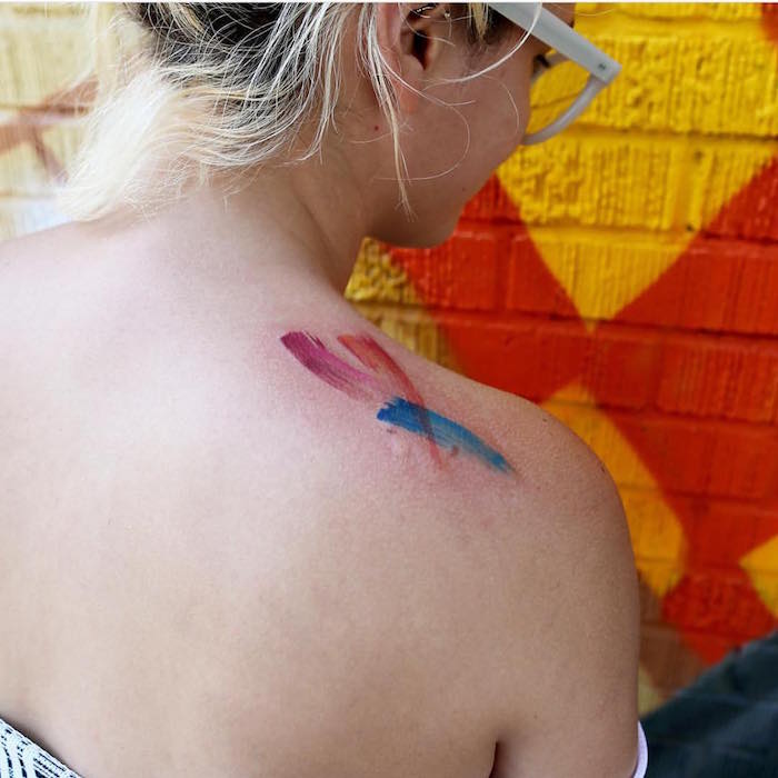 idée de tatouage abstrait original style coups de pinceaux en couleurs aquarelle sur épaule de femme