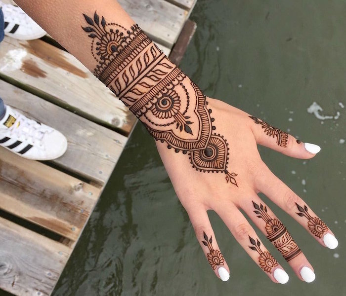 dessin henné main sur doigts et poignet style bracelet en dentelle avec ongles blancs et adidas superstar