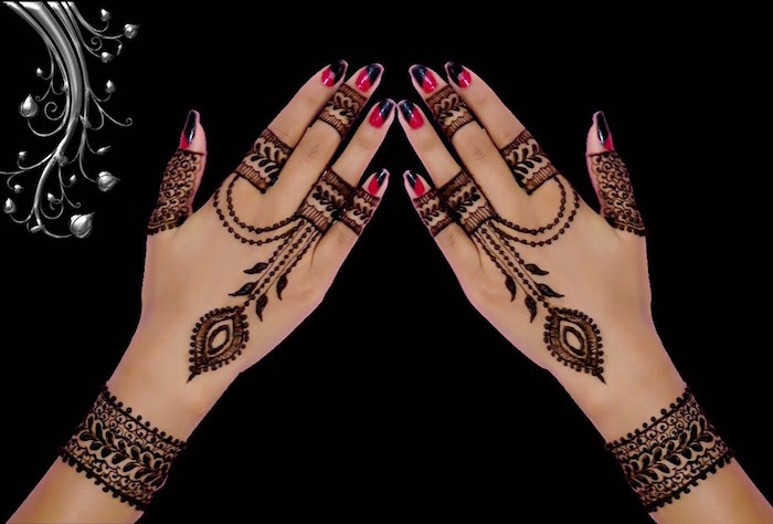 dessins symétriques au henné sur les mains et poignets style bagues et bracelets