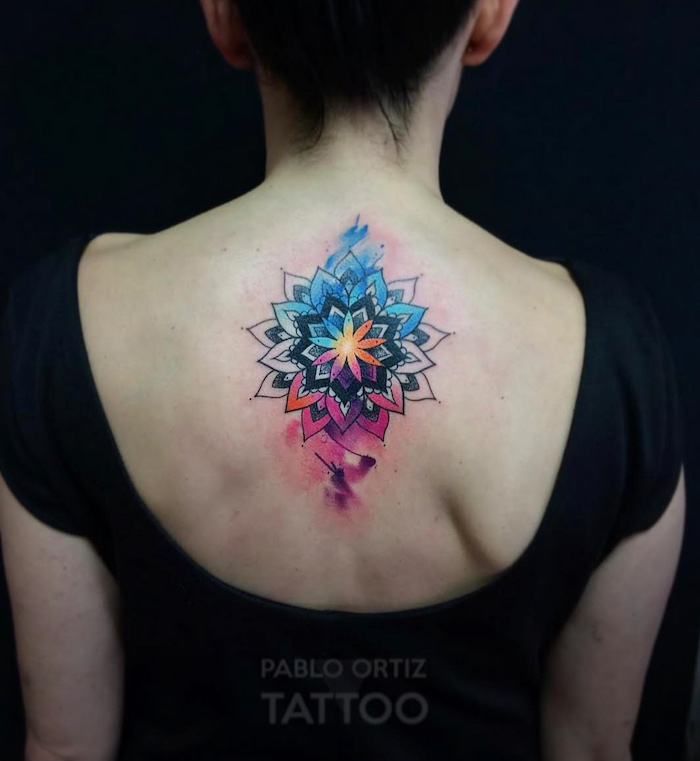 tatouage aquarelle mandala noire avec couleurs et taches sur dos de femme par pablo ortiz