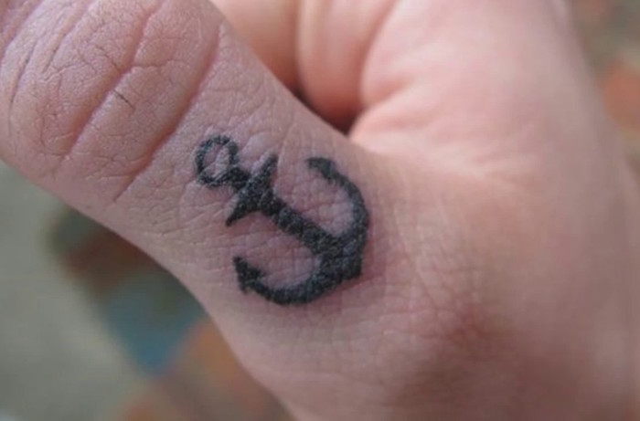 mini tatouage discret homme petite ancre marine noire sur le pouce