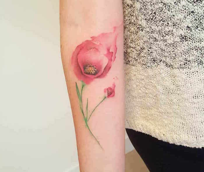 tatouage tulipe rose avec tige verte réaliste en relief style aquarelle sur avant bras femme