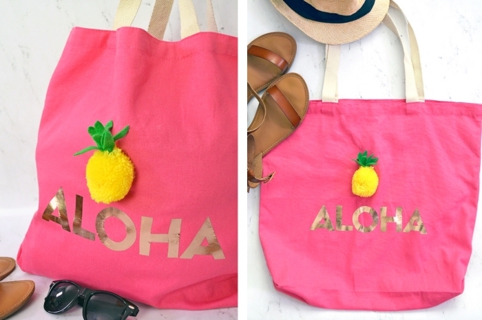 modèle de tote bag en tissu rose avec poignée beige et jolie déco en lettres dorés aloha avec petit anans en pompon jaune