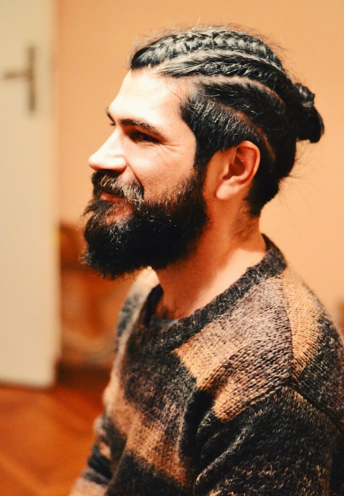 coiffure avec tresse plaquée en chignon pour homme blanc avec barbe style hipster