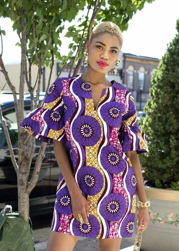 allure chic et féminin en robe tunique à motifs graphiques africains accessoirisée avec des bijoux en or massifs, vetement africain moderne et chic