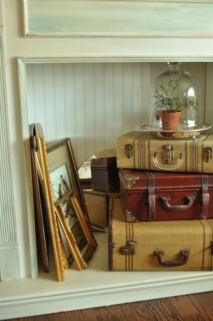 valises vintage et miroir aux vieux encadrements comme déco pour la cheminée
