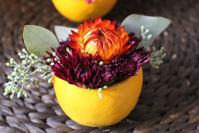 vase en demi orange creusé et rempli de fleurs, deco table automne, modele de centre de table original