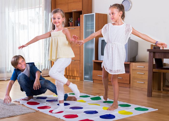 comment jouer le twister, idée d activité anniversaire, jeu d adresse amusante avec une toile à cercles colorés