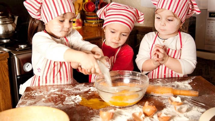 premier cours de cuisine des enfants vêtus comme des chefs de restaurant qui fond la cuisine, patisserie enfant