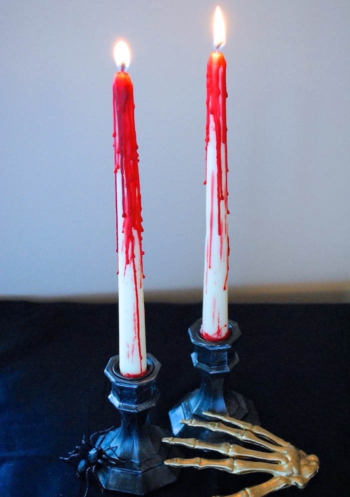 deco halloween fait maison, bougie blanche décorée de cire rouge effet sang, main squelette artificelle