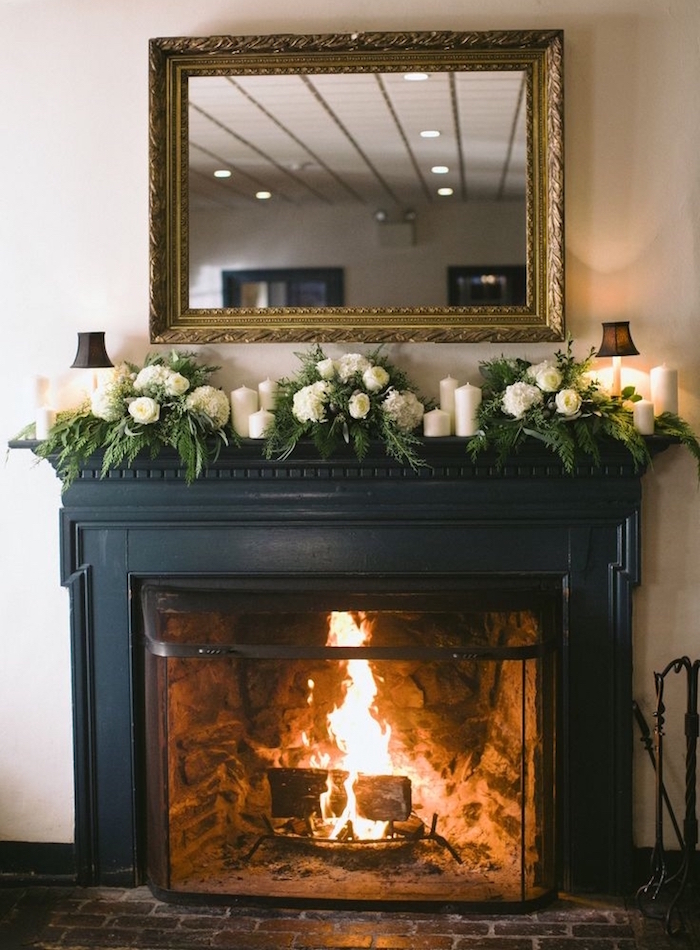 décoration cheminée avec manteau noir mat sur mur blanc, bouquets roses blanches et miroir au cadre doré