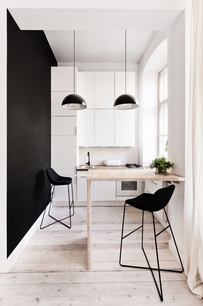 comment décorer une cuisine tendance minimaliste en blanc et bois, exemple d'ilot central petite cuisine avec chaises de bar noires