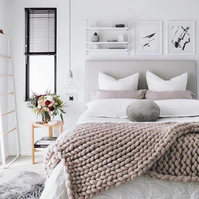 chambre cosy et belle au style scandinave, plaid tricot gris, tapis fourrure, échelle blanche, porte-cadres
