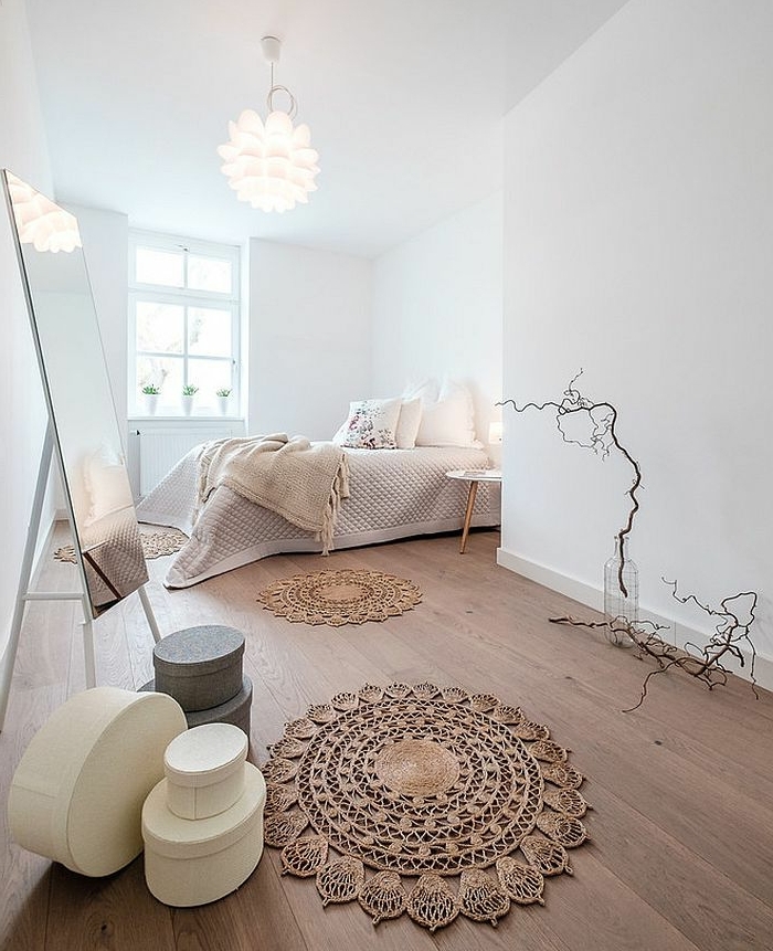 tapis macramé, murs blancs dans une grande chambre cosy, miroir rectangulaire, plafonnier blanc