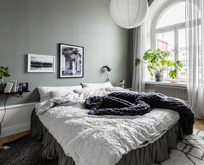 lit cocooning en gris et blanc, mur peint gris, plafonnier boule blanche, fenêtre arc, petite étagère