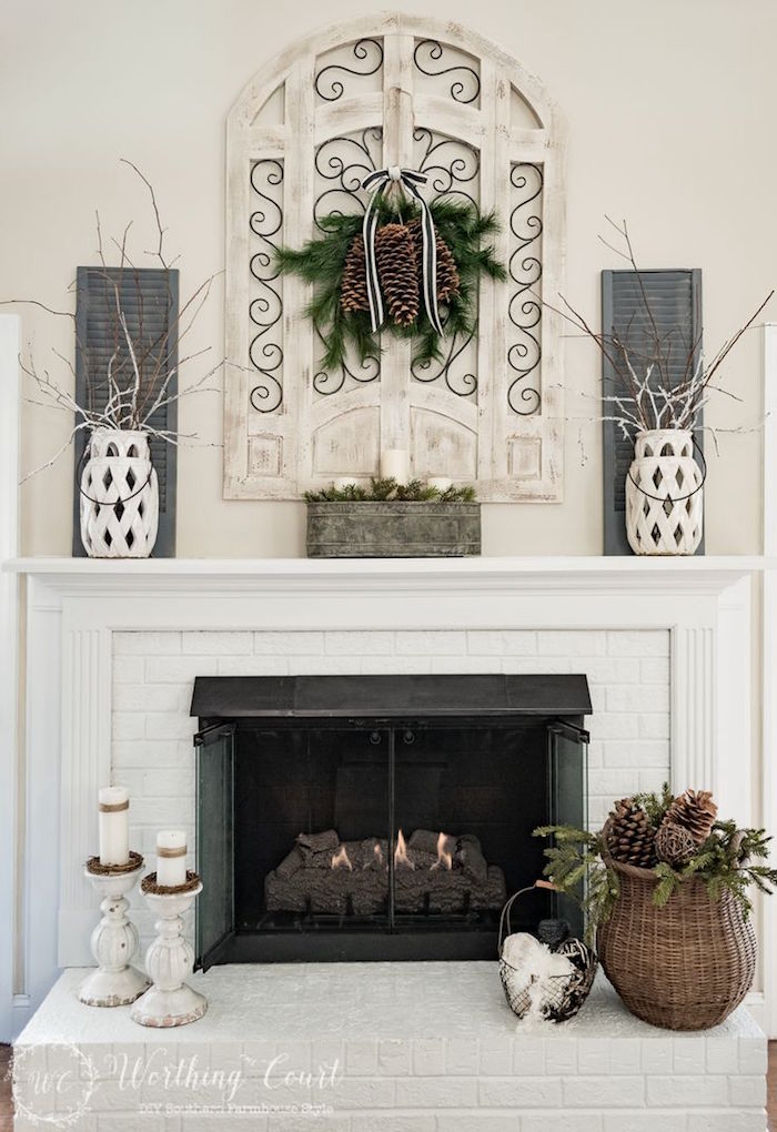 décorer cheminée en hiver avec pommes de pin, bougies, vases, brindilles, déco symétrique