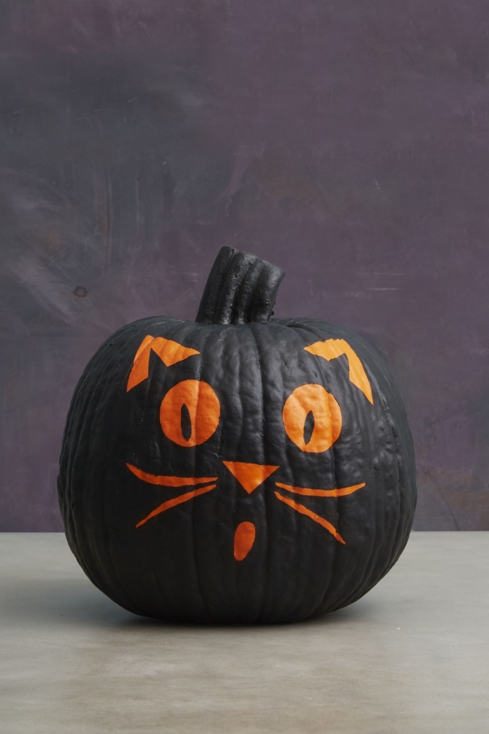 faire une décoration citrouille, modèle de citrouille peinte en noir avec dessin tête de chat, idée comment décorer une citrouille