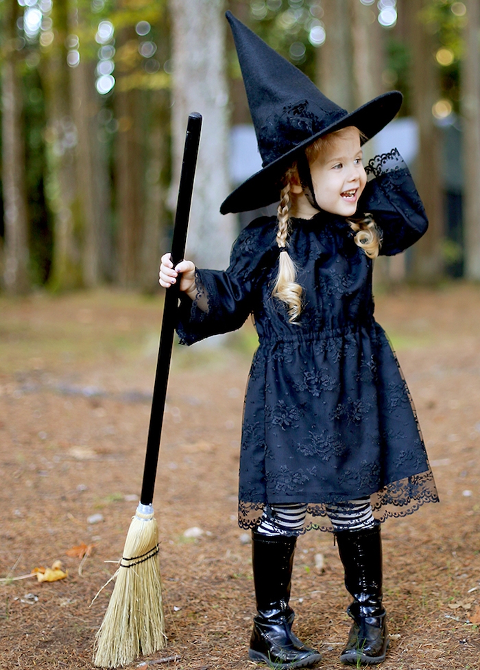 deguisement de sorciere pour petite fille, robe noire dentelle, chapeau de sorciere, tresses enfant fille, bottes noires, balai
