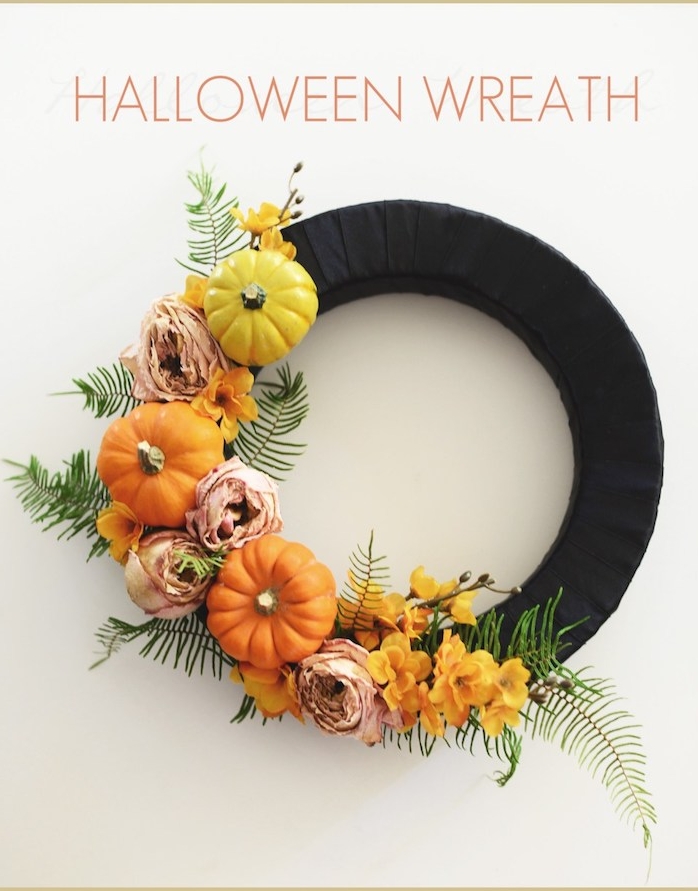 couronne de halloween en cerceau en bande noire avec decoration de potirons décoratifs, fleurs d automne et feuilles
