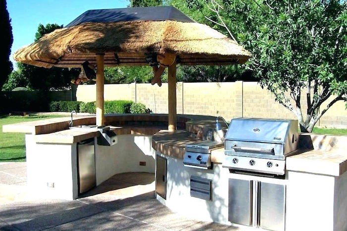 photo de cuisine d'été couverte d'un toit en bois et grill au gaz et plan de travail en forme de s