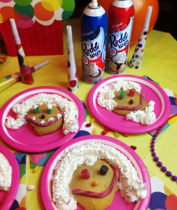 decoration biscuit original avec de la crème fraîche, dragées, gélifiés et autres bonbons dans une assiette rose