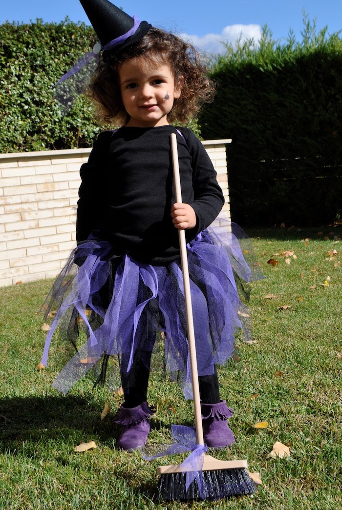 petite fille sorcière en blouse noire, jupe en tulle violette, chapeau sorcière pointu, balai simple, idée mignonne petite sorcière