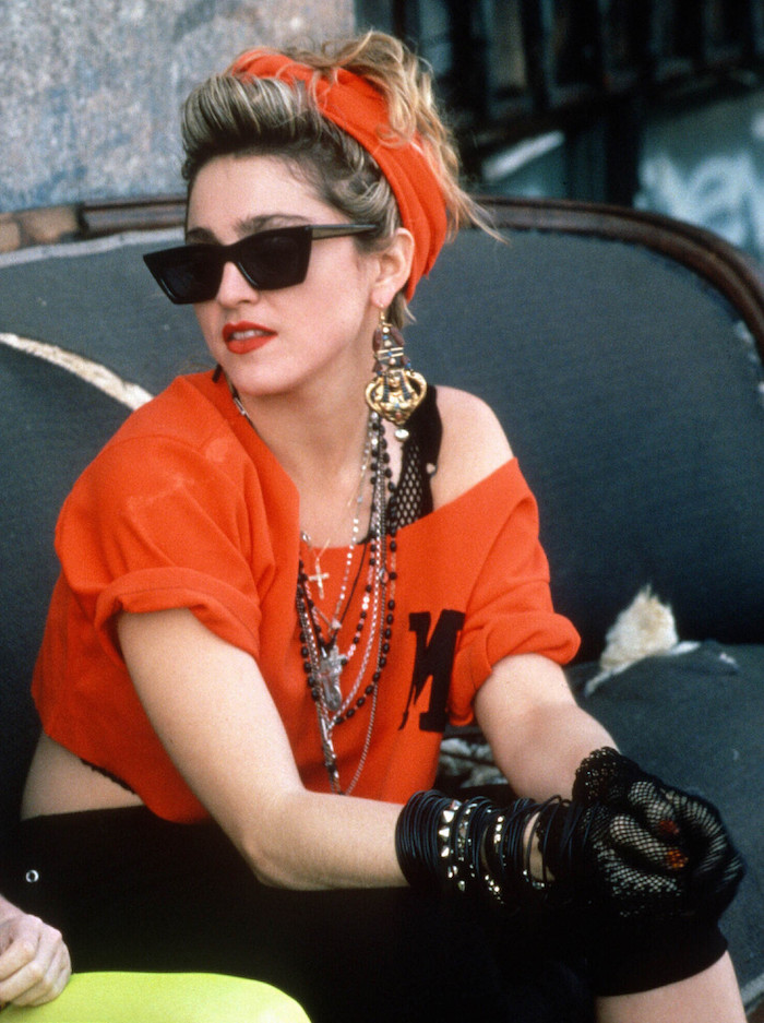 Look année 80, vêtements d'occasion musique populaire glamour look de Madonna avec une tee-shirt épaule dénudée, lunettes de soleil, bandana