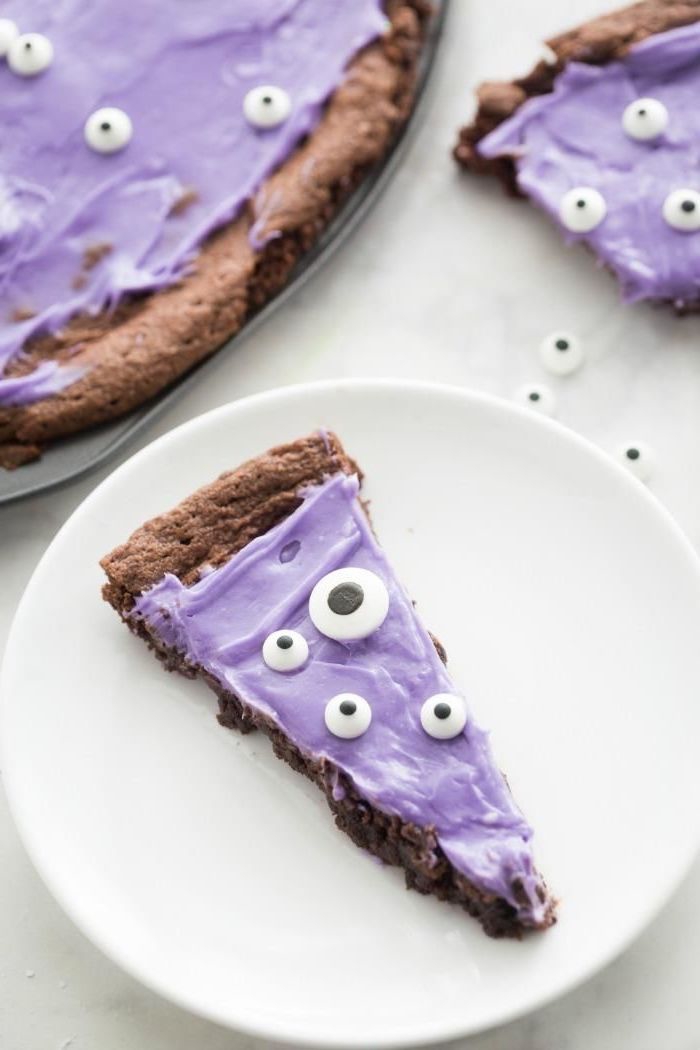 pizza aux brownies monstres d'halloween au glaçage au beurre violet décoré de bonbons yeux, dessert original thématique pour le repas d'halloween