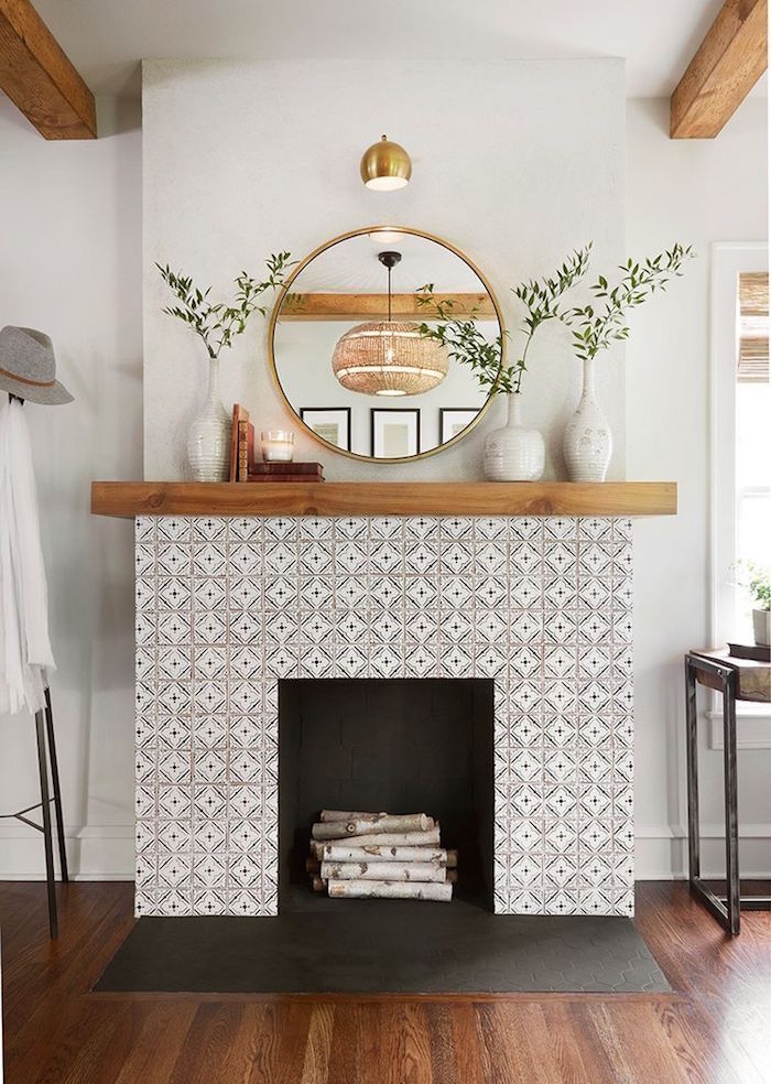 photo décoration de salon sur parquet avec manteau de cheminée déco en mosaique type crédence blanche, support en bois avec vases et miroir rond doré