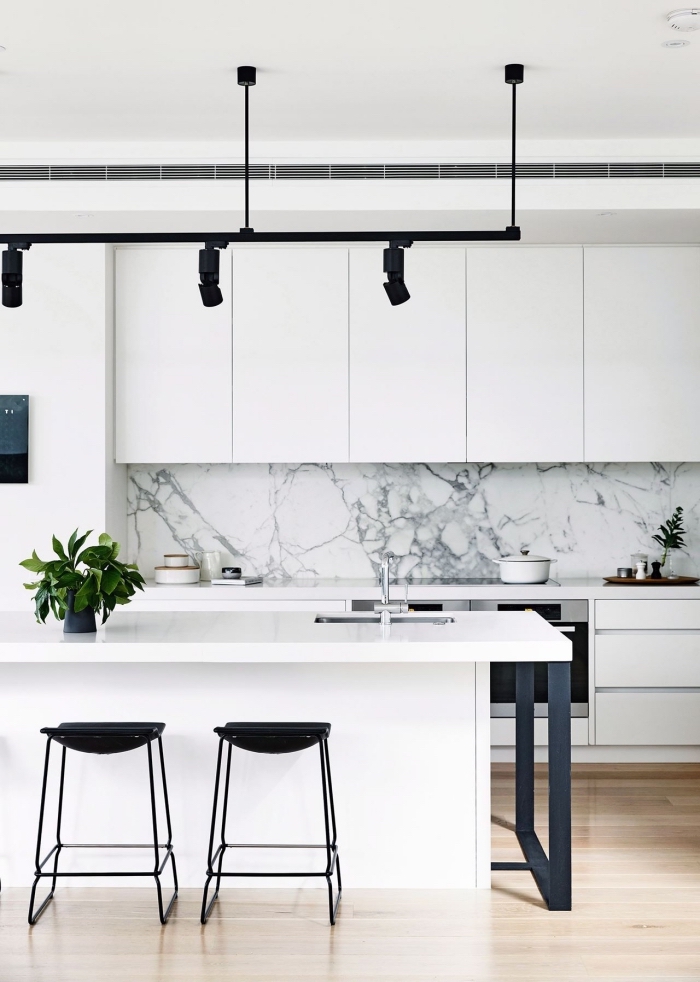 modèle de cuisine blanche avec parquet bois clair et crédence marbre à déco avec accessoires en noir mate