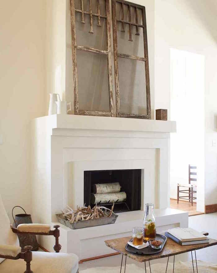 moderniser une cheminée dans déco salon minimaliste avec manteau blanc carré, fenetre bois vintage comme objets décoration, meubles retro en bois rustique
