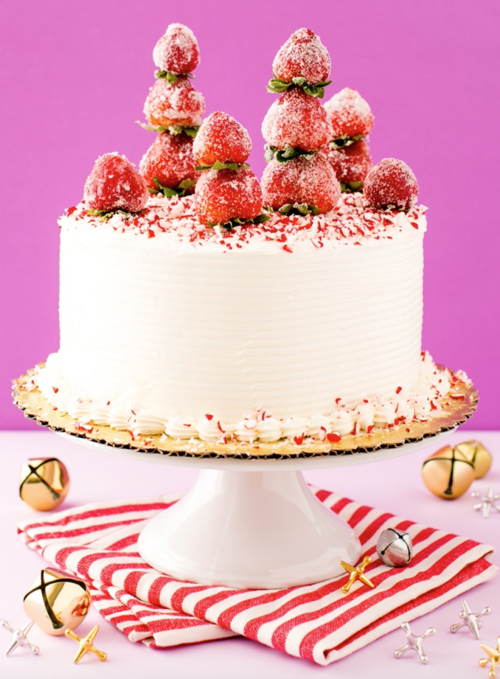 idée pour une jolie décoration de gâteau d'hiver au glacage blanc à la crème au beurre, décoré de fraises et de sucre 