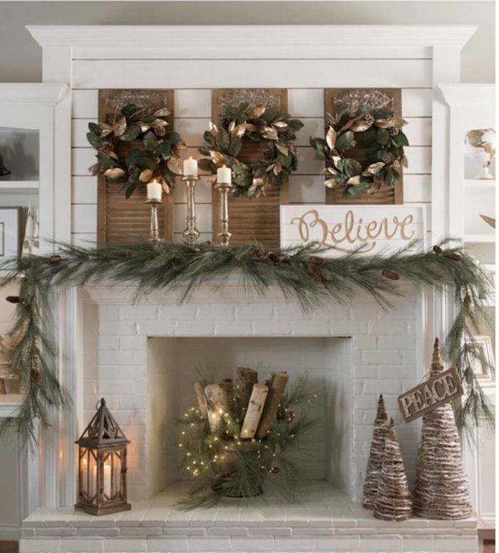 idée de déco pour cheminée thème hiver feerique avec couronnes feuilles guirlande de pin panier de buchettes, briques blanches