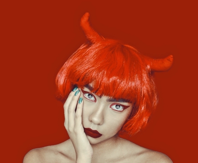 maquillage de diablesse avec bouche rouge mat et un regard souligné par un eye-liner coloré, déguisement diablesse réussi perruque carré rouge avec frange et cornes de diable