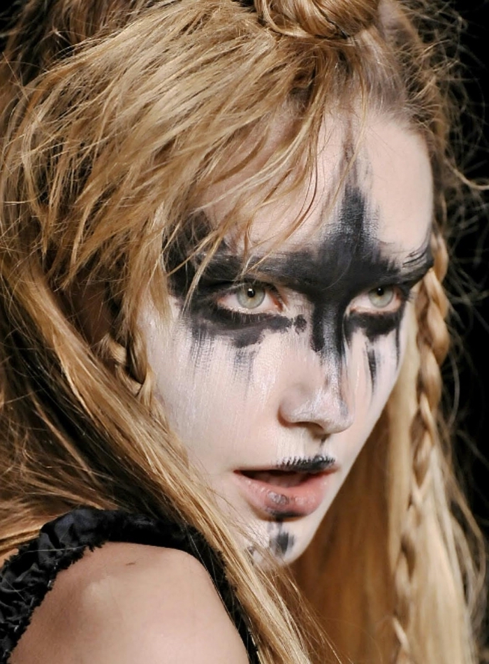 maquillage guerrière viking au visage peint de noir et blanc, coiffure sauvage de femme viking avec mini-tresses