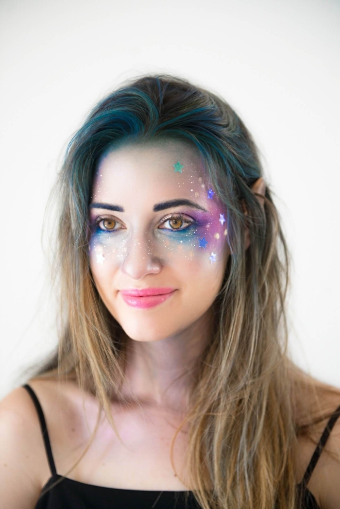 idée de maquillage halloween facile inspiré de la galaxie réalisé avec des fards aux couleurs bleu, violet et argenté, appliqués sur les coins externes des yeux, les joues et le front